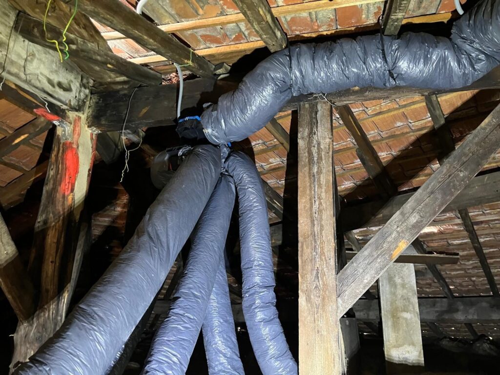 Réseau de gaines de VMC raccordé sous la toiture d’une maison à Malakoff